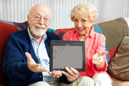 老夫妇拿着一张空白的平板电脑准备好你的文字或照片图片