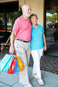 快乐的情侣在购物中心带着袋走来去图片