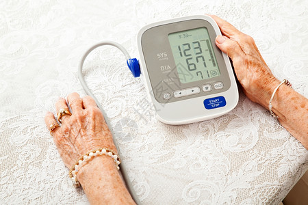 一名年长妇女的手在家庭测量仪上检查她的血压结果很低图片