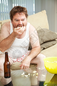 在家的中年男子沙发上看电视喝啤酒吃爆米花穿着内衣图片