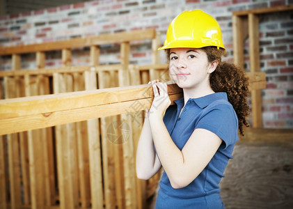 年轻女学徒在建筑工地上布置板图片