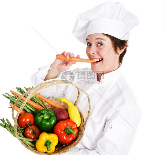 快乐的女厨师拿着一篮新鲜的有机本地生产农品吃着生胡萝卜图片