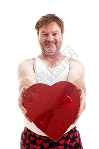 Scruffy中年男子给了你一盒心形糖果用于情人节图片