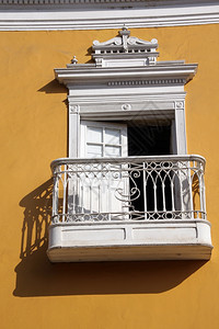 秘鲁北部Trujillo街上的黄墙和白阳台图片
