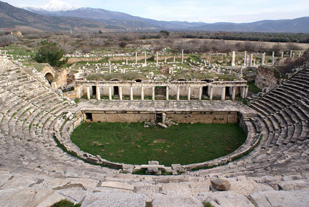 Aphrodisias的老石块剧院废墟和山丘图片