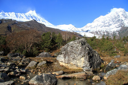 尼泊尔Manaslu附近大岩石和山河图片