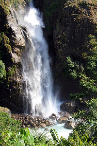 尼泊尔山区瀑布和绿草中的白水图片
