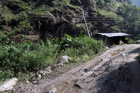 Nepal山区湿土路和小屋图片