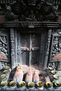 在尼泊尔巴克塔普尔的ChanguNarayan寺庙紧闭的大门附近的神像图片