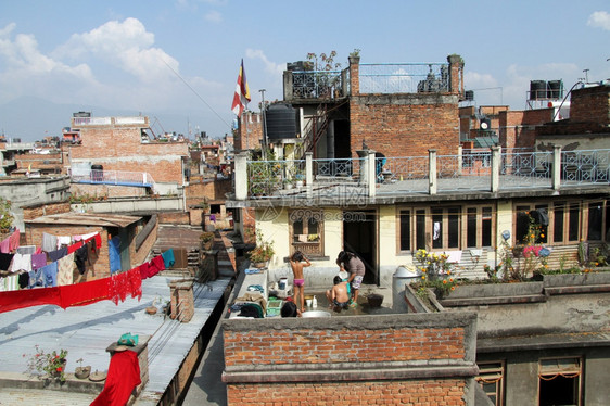 在尼泊尔帕坦Patan的建筑屋顶上有人洗澡图片