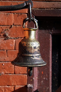 小铜铃在寺庙砖墙附近挂着图片