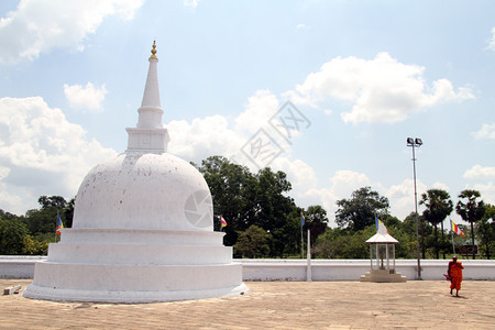 在斯里兰卡Anuradhadhapura的白石塔附近行走的僧侣图片