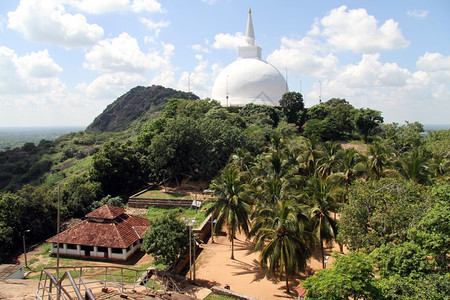 斯里兰卡Mihintale的Mahastupa和有瓷砖屋顶的建筑图片