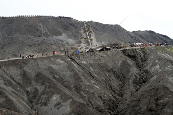 人们和马匹步行到印度尼西亚Bromo火山的上图片