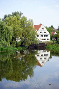 德国沃尼茨坦2015年9月1日河边的老房子和大树图片
