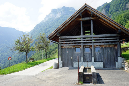 瑞士公路附近的木林棚和喷泉图片