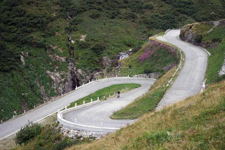 瑞士阿尔卑斯山的塞潘廷公路上的自行车骑手图片