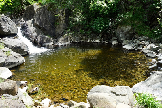 小瀑布和带岩石阳光的环形盆地图片