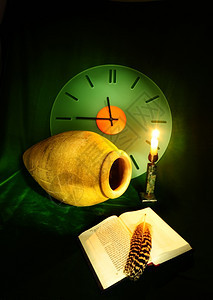 仍然活在时钟安法拉开放圣经和绿天鹅绒上的亮蜡烛之中图片
