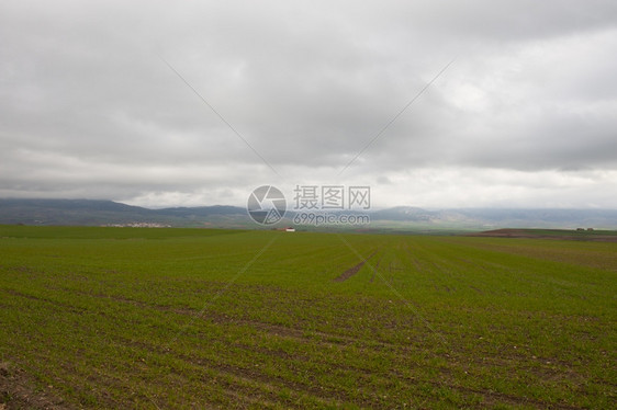 中世纪西班牙城镇周围环绕着雨天的田地和山图片