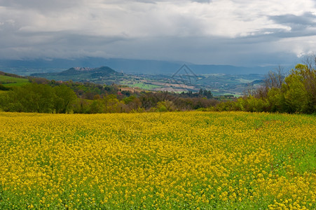 中世纪意大利城镇周围环绕着雨天的田地和山图片
