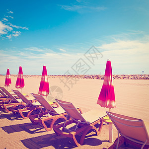 法国里维埃拉低季节的海滩伞状和太阳床VintageStyleTonedPicture图片