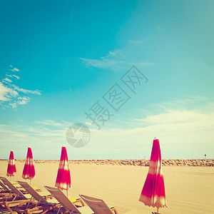 法国里维埃拉低季节的海滩伞状和太阳床VintageStyleTonedPicture图片