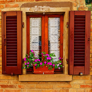 意大利窗口装有开放木制百叶窗装饰用鲜花图片