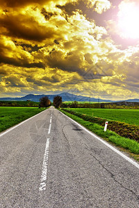 意大利地貌布满柏油路清晨在草原之间日出意大利农业田野和牧场图片