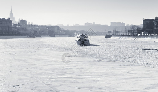 在阳光明媚的寒冬日莫斯科河上冰冻的船图片