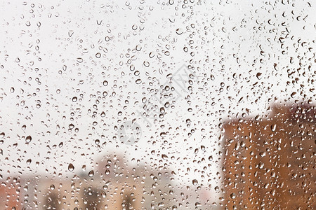 带有城市风景背的玻璃窗口上雨滴图片