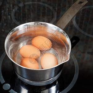 鸡蛋在厨房电炉的金属锅中煮鸡蛋图片