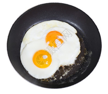 白色背景隔离的煎锅中两个蛋的顶部视图图片