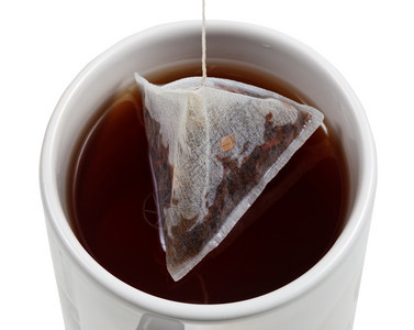 最顶端的茶叶泡在杯里袋紧闭着白色背景的孤立图片