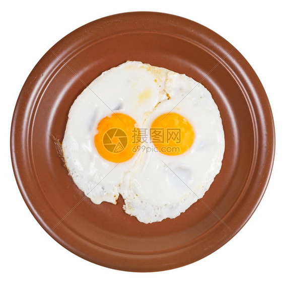 以白色背景隔离的陶瓷棕色板块上两个煎蛋的顶部视图图片