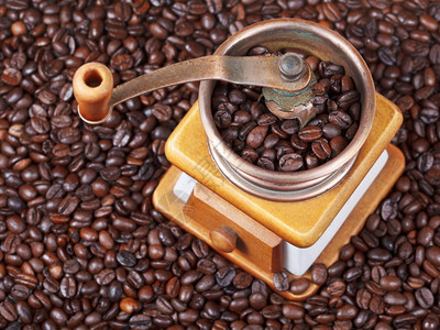 在许多烤咖啡豆上可看到回溯式手制咖啡研磨机的顶部图片