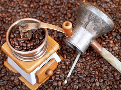 在许多烤咖啡豆上使用二手咖啡研磨机和铜锅图片