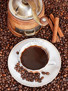 上图一杯咖啡和烤咖啡豆配上古典手工磨坊和肉桂高清图片