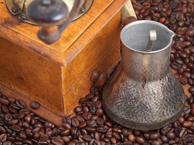 在许多烤咖啡豆上加二手咖啡机和铜锅图片