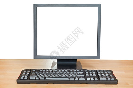 白色背景上隔开的木制表格上屏幕和键盘图片