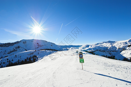 法国摩尔津阿沃里亚兹太阳港地区光明媚的日落山区雪坡上滑的轨图片