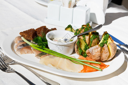 冷开胃菜在户外餐厅各种盐鱼和白板上烤土豆的图片