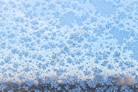 寒冷的冬通过雪花和窗玻璃上的霜城市蓝色的黄昏图片