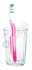 玻璃中的粉红色牙刷白背景上隔绝的玻璃粉红色牙刷图片