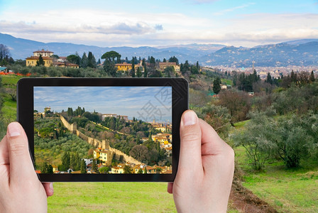 旅行概念在意大利佛罗伦萨Toscany用移动小工具拍摄绿色山丘照片的游客图片