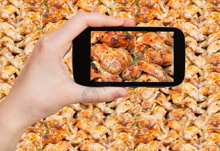 摄影食品照片概念旅游者用移动工具在热盘上拍摄烤辣鸡翅膀的照片图片