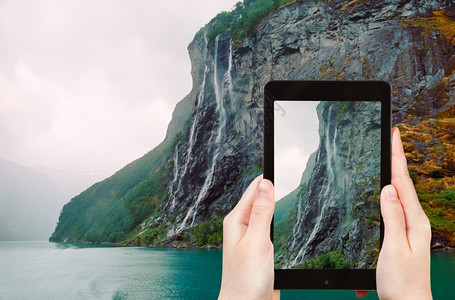 旅游理念游客用手机拍下盖兰热峡湾七姐妹瀑布图片