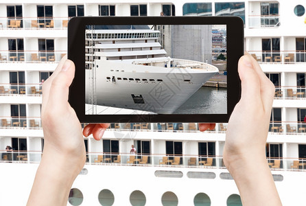 旅行概念游客在智能手机上拍摄大型游轮图片