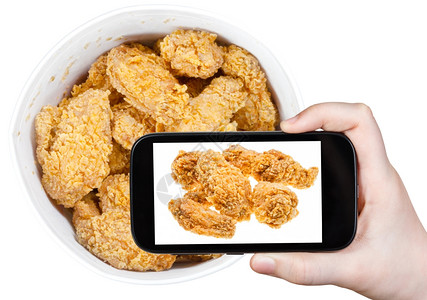 照片拍摄食物概念游客用智能手机篮子拍摄热炸鸡翅膀照片美国图片