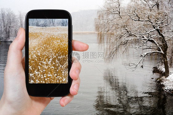 旅行概念游客拍摄美国智能手机冬季下雪时哈德逊河的景象图片